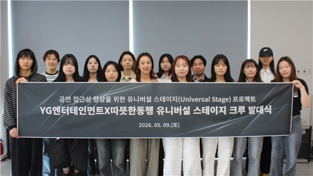 따뜻한동행과 YG엔터테인먼트가 진행한 ‘유니버설 스테이지 크루’ 발대식에서 참여자들이 현수막을 들고 기념촬영을 하고 있다. 따뜻한동행 제공