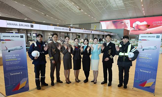 Asiana Airlines and Korean Air flight and cabin crew employees pose for a commemorative photo at Incheon International Airport Terminal 2 on May 14 to mark Asiana Airlines’ relocation to Terminal 2 on Jan. 14 [JOONGANG ILBO]