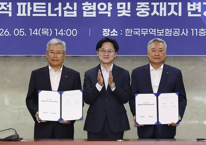 14일 중구 무역보험공사에서 열린 ‘한전-한수원 간 원전수출 전략적 파트너십 협약 및 중재지 변경 협약 체결식’에서 김정관 산업통상부 장관(가운데)이 협약서에 서명한 김동철 한국전력 사장(왼쪽), 김회천 한국수력원자력 사장(오른쪽)과 함께 기념사진을 찍고 있다. [연합]