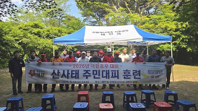 태안군은 지난 13일 태안읍 상옥리 산사태 취약지역에서 '극한호우 산사태위험지역 주민대피 훈련'을 진행하고 기념촬영을 하고 있다. ⓒ태안군 제공