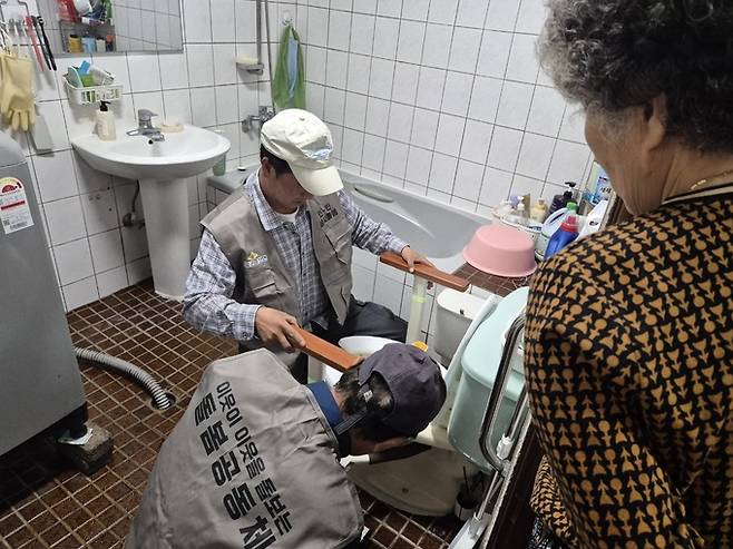 ▲ 의성군 춘산면 행복기동대 대원들이 12일 거동이 불편한 취약계층 노인가구를 찾아 화장실 변기 주변에 안전바를 설치하고 있다. 의성군 제공