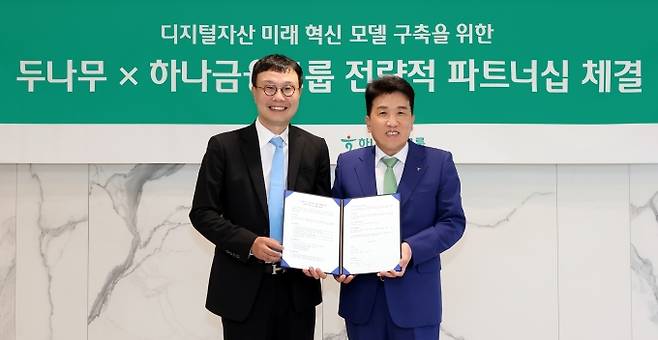▲15일 하나금융그룹 명동사옥에서 개최된 협약식에서 함영주 하나금융그룹 회장(사진 오른쪽)이 김형년 두나무 부회장(사진 왼쪽)과 함께 기념촬영을 하고 있다. (사진=하나금융)