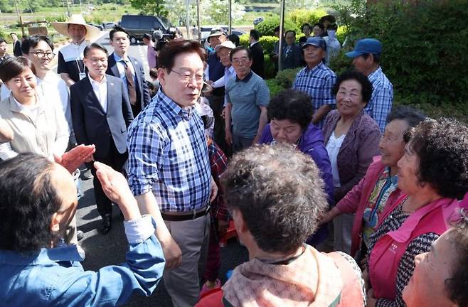 이재명 대통령이 15일 대구 군위군 소보면 도산1리 마을에서 모내기에 앞서 주민들과 인사하고 있다. 연합뉴스