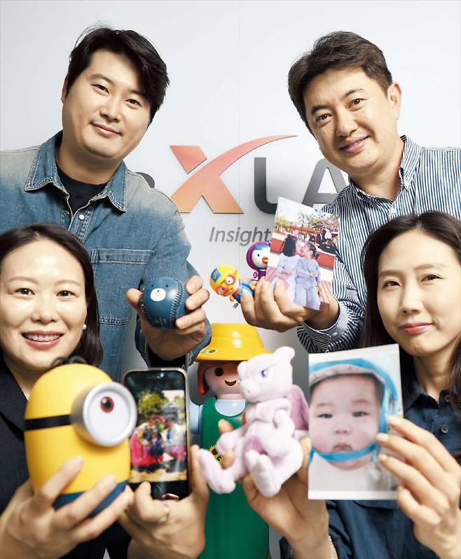 7일 서울 양재동에 있는 유투엑스랩 본사 사무실에서 직원들이 자녀의 사진과 장난감을 들고 기념 촬영을 하는 모습. 직원은 50명이 안 되지만, 대기업 못지않은 가족 친화 제도를 갖춘 덕분에 장기 근속 직원이 많다고 한다. /장경식 기자