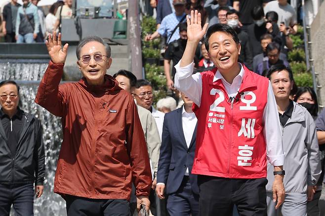15일 서울 중구 청계천 인근에서 국민의힘 오세훈 서울시장 후보가 이명박 전 대통령과 만나 시민들을 향해 손을 흔들고 있다./ 연합뉴스