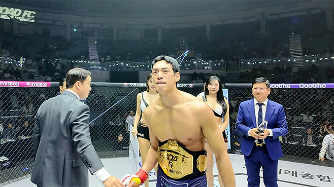 대한MMA총협회 정문홍 회장이 2025년 12월 서울특별시 중구 장충체육관 특설 케이지에서 윤태영의 초대 로드FC 웰터급 챔피언 등극을 축하해주고 있다. 사진=세계격투스포츠협회