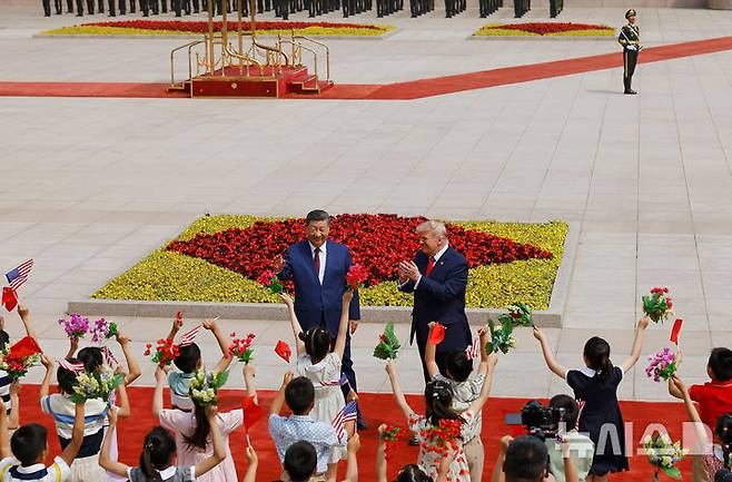 [베이징=AP/뉴시스] 14일 중국 베이징 인민대회당에서 시진핑 중국 국가주석이 도널드 트럼프 미국 대통령을 위한 환영식을 연 가운데 어린이들이 중국과 미국 국기를 들고 있다. 2026.05.14.