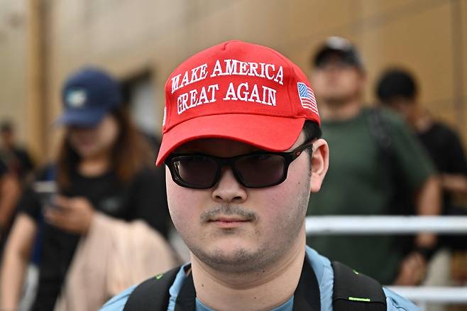 MAGA 모자를 쓴 한 사람이 지난 15일(현지시간) 도널드 트럼프 미국 대통령을 태운 에어포스원의 이륙을 기다리며 중국 베이징 서우두 국제공항 밖에 서 있다. AFP연합뉴스