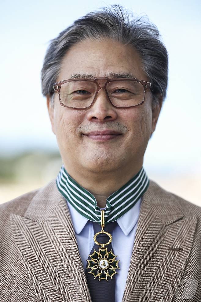 제79회 칸 국제영화제 경쟁부문 심사위원장인 박찬욱 감독이 17일(현지 시각) 프랑스 남부 칸에서 열린 프랑스 문화예술공로훈장 수훈식에서 최고 등급인 ‘코망되르’를 받은 뒤 훈장을 목에 걸고 있다. 2026.5.17 ⓒ 뉴스1 ⓒ 로이터=뉴스1