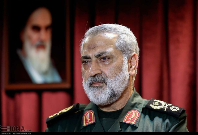 이란군 수석대변인을 맡고 있는 아볼파즐 셰카르치 이란 이슬람혁명수비대(IRGC) 준장이 미국·이스라엘의 공습으로 피살한 전임 최고지도자 알리 하메네이의 초상을 배경으로 앉아 있다. [이란 국영 IRNA 통신 보도사진]