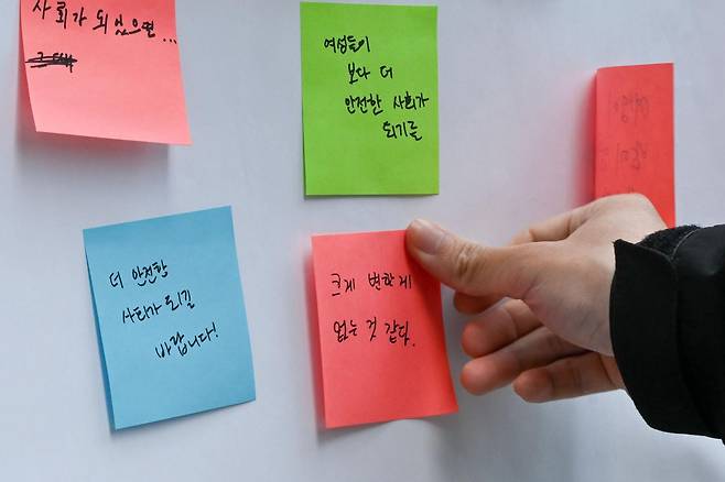 강남역 살인사건 10주기를 앞둔 6일 시민들이 서울 강남역 10번 출구 앞에서 '무엇이 변하고 변하지 않았는지' 묻는 말에 자신의 생각을 포스트잇에 적어 메모판에 붙이고 있다. 박지연 인턴기자