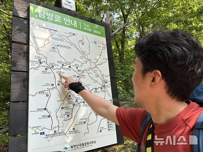 [서울=뉴시스]신유림 기자=15일 오후 출동 지령을 받은 북한산 산악구조대 김하름(41) 소방장이 탐방로를 보며 이동 경로를 확인하고 있다. 2026.05.15. spicy@newsis.com