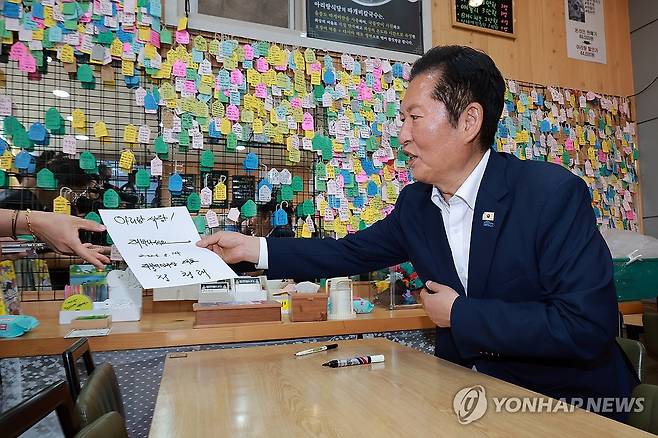 서명 전달하는 민주당 정청래 총괄상임선대위원장 (울릉=연합뉴스) 신현우 기자 = 더불어민주당 총괄상임선대위원장인 정청래 대표가 14일 경북 울릉군 저동 한 식당을 방문해 서명한 뒤 식당 주인에게 전달하고 있다. 2026.5.14 nowwego@yna.co.kr