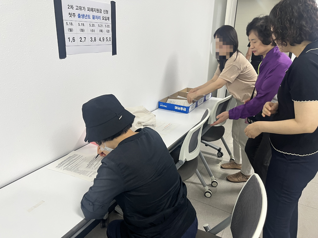 범어3동 행정복지센터 직원들의 도움을 받아 어르신들이 신청서를 작성하고 있다. 김정원 기자