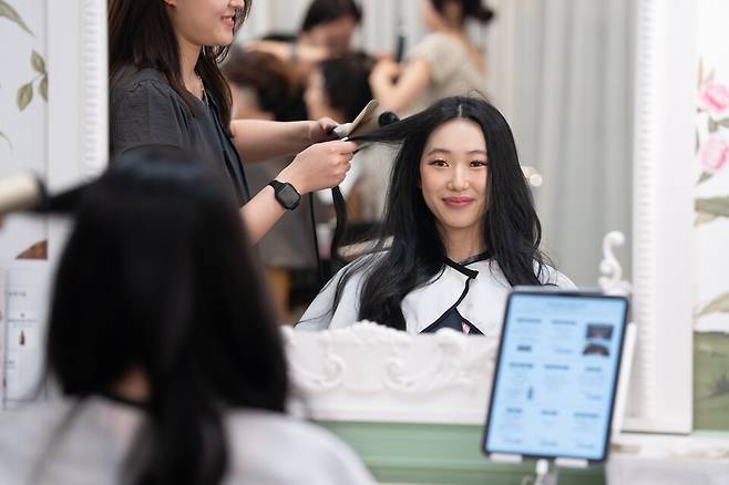 12일 오전 부산 북항으로 입항한 로얄캐리비안 스펙트럼 오브 더 시즈호의 탑승객 브리애나가 서면 내 K-헤어살롱을 찾아 한국식 스타일링을 경험하고 있다. /한국관광공사 제공