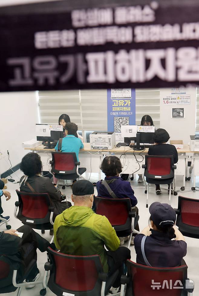[부산=뉴시스] 하경민 기자 = 정부 고유가 피해지원금 2차 신청·지급 첫날인 18일 부산 부산진구 개금3동행정복지센터에서 주민들이 선불카드형 지원금을 받고 있다. 2026.05.18. yulnetphoto@newsis.com