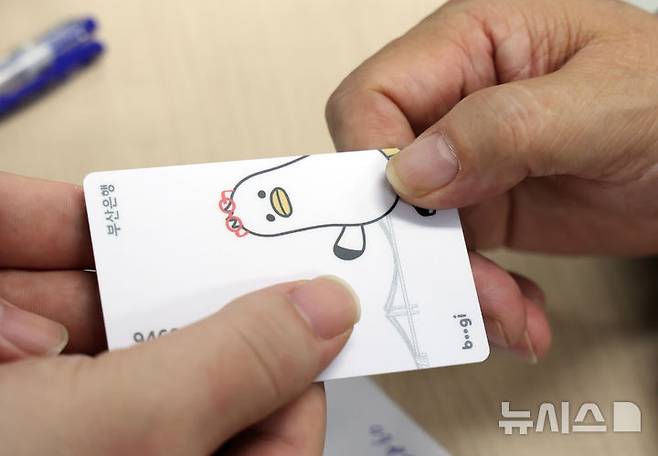 [부산=뉴시스] 하경민 기자 = 정부 고유가 피해지원금 2차 신청·지급 첫날인 18일 부산 부산진구 개금3동행정복지센터에서 주민들이 선불카드형 지원금을 받고 있다. 2026.05.18. yulnetphoto@newsis.com