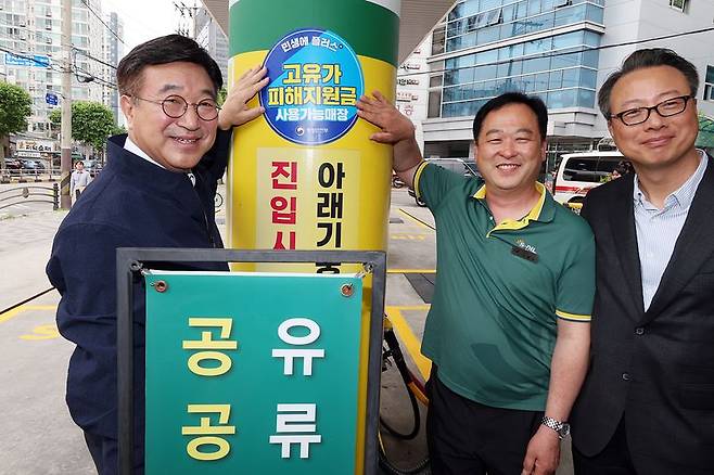 윤호중 행정안전부 장관(맨왼쪽)이 고유가지원금 2차 신청 둘째날인 19일 오전 서울 영등포구 문래동 인근 주유소를 찾아 사용가능 매장 스티커를 부착하고 있다. 행정안전부 제공