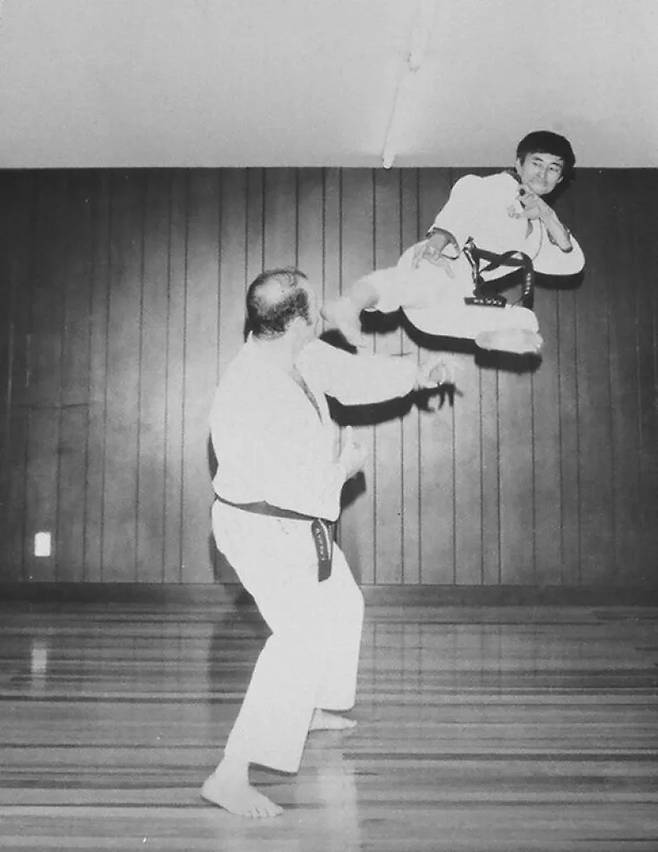 Dr. Manuel Mondragon y Kalb (left) reacts as Moon demonstrates a flying kick in an undated photo from the early years of Taekwondo in Mexico. Mondragon invited Moon to remain in Mexico in 1968 to teach Taekwondo, helping lay the foundation for the sport’s growth in the country. (Moon Dai-won)