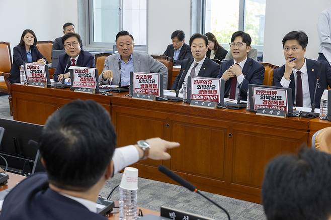 18일 국회에서 열린 행정안전위원회 전체 회의에서 국민의힘 의원들이 민주당 정원오 서울시장 후보 폭행 사건의 의혹이 쓰여진 손팻말을 노트북에 붙인 뒤 이를 항의하는 민주당 의원들과 설전을 벌이고 있다. [연합뉴스]