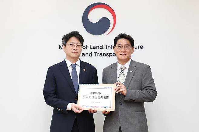 [화성=뉴시스] 윤성진 화성시장 권한대행(사진 오른쪽)이 19일 홍지선 국토교통부 제2차관에게 화성시 주요 현안과 정책 건의서를 전달하고 있다. (사진=화성시 제공) 2026.05.19. photo@newsis.com  *재판매 및 DB 금지