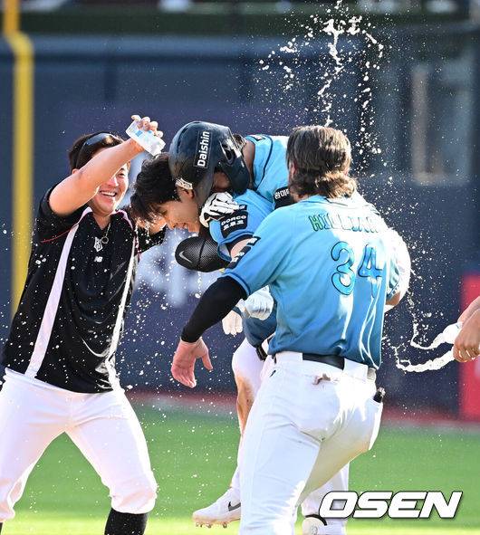 [OSEN=수원, 최규한 기자] 17일 수원 KT위즈파크에서 ‘2026 신한 SOL Bank KBO리그’ KT 위즈와 한화 이글스의 경기가 열렸다.이날 경기는 접전 끝에 KT가 9회말 1사 1, 3루에서 터진 이정훈의 끝내기타에 힘입어 8-7 승리를 거뒀다.9회말 1사 1, 3루 상황 KT 이정훈이 끝내기 안타를 날리고 동료들의 물세례를 받고 있다. 2026.05.17 / dreamer@osen.co.kr