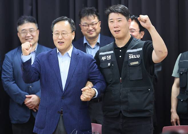 20일 경기도 수원시 장안구 경기고용노동청에서 열린 삼성전자 임금협상을 마친 후 여명구 삼성전자 DS(디바이스솔루션·반도체 사업 담당) 피플팀장과 최승호 삼성그룹 초기업노동조합 삼성전자지부 위원장이 잠정 합의한에 서명한 후 파이팅을 외치고 있다. (사진=뉴스1)
