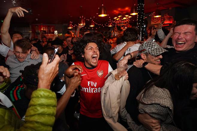 <YONHAP PHOTO-3414> Arsenal supporters celebrate in a pub near the Arsenal stadium after Arsenal's soccer team won the Premier League title in London, Tuesday, May 19, 2026.(AP Photo/Alberto Pezzali)/2026-05-20 07:47:32/<저작권자 ⓒ 1980-2026 ㈜연합뉴스. 무단 전재 재배포 금지, AI 학습 및 활용 금지>