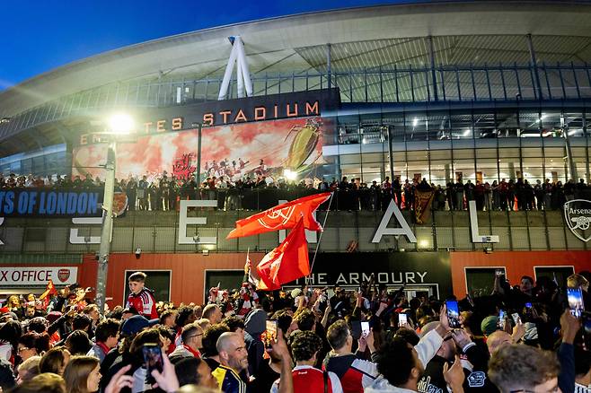 <YONHAP PHOTO-3361> Arsenal fans celebrate their team wining the English Premier League, outside the Emirates Stadium in London on May 19, 2026. Arsenal ended a 22-year wait to be crowned Premier League champions on May 19. Gunners boss Mikel Arteta completed his quest to take Arsenal back to the promised land as Manchester City's draw away to Bournemouth on May 19, sealed a long-awaited Premier League title. (Photo by Brook Mitchell / AFP)/2026-05-20 07:19:28/<저작권자 ⓒ 1980-2026 ㈜연합뉴스. 무단 전재 재배포 금지, AI 학습 및 활용 금지>