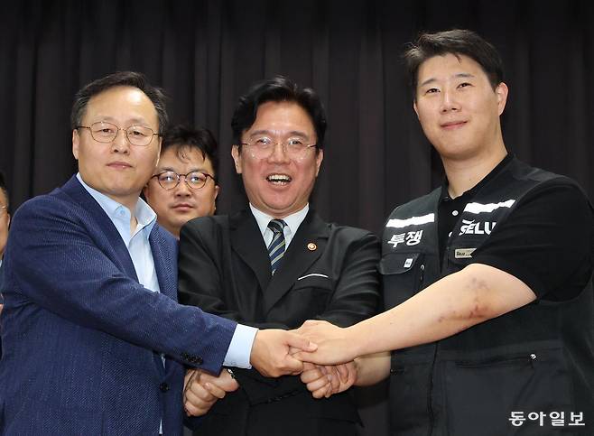 20일 경기 수원시 장안구 경기고용노동청에서 열린 삼성전자 임금협상을 마친 후 여명구 삼성전자 DS(디바이스솔루션·반도체 사업 담당) 피플팀장(왼쪽부터)과 김영훈 고용노동부 장관, 최승호 삼성그룹 초기업노동조합 삼성전자지부 위원장이 잠정 합의한에 서명한 후 손을 맞잡고 파이팅을 외치고 있다. 양회성 기자 yohan@donga.com