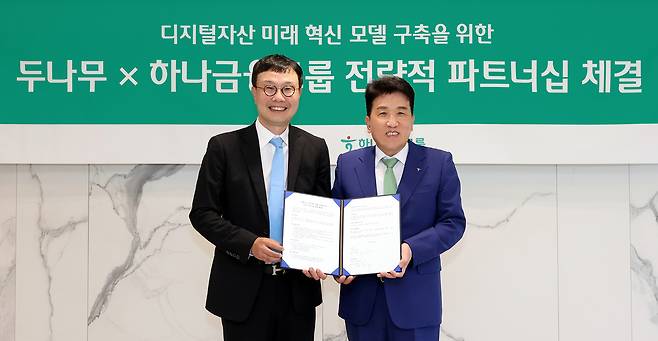 함영주 하나금융그룹 회장이 15일 하나금융그룹 명동사옥에서 두나무·하나금융그룹 전략적 파트너십을 체결한 후 김형년 두나무 부회장과 기념 촬영하고 있다. 하나금융그룹 제공