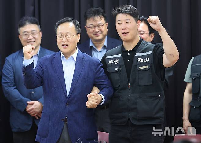 [수원=뉴시스] 김종택기자 = 20일 경기도 수원시 장안구 경기고용노동청에서 열린 삼성전자 임금협상을 마친 후 여명구 삼성전자 DS(디바이스솔루션·반도체 사업 담당) 피플팀장과 최승호 삼성그룹 초기업노동조합 삼성전자지부 위원장이 잠정 합의한에 서명한 후 파이팅을 외치고 있다. (공동취재) 2026.05.20. photo@newsis.com