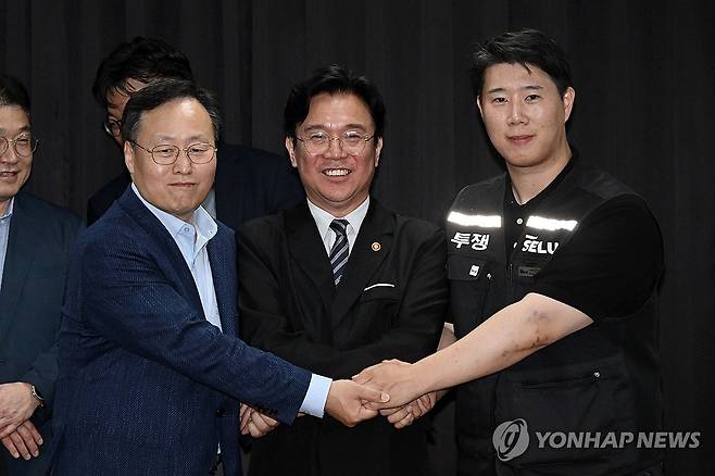 삼성전자 파업 유보 (수원=연합뉴스) 홍기원 기자 = 20일 경기도 수원시 장안구 경기고용노동청에서 열린 삼성전자 임금협상을 마친 후 여명구 삼성전자 DS(디바이스솔루션·반도체 사업 담당) 피플팀장과 최승호 삼성그룹 초기업노동조합 삼성전자지부 위원장이 잠정 합의안에 서명한 후 김영훈 고용노동부 장관과 기념촬영을 하고 있다. 2026.5.20 [공동취재] xanadu@yna.co.kr