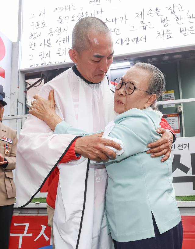 국민의힘 박민식 북갑 보궐선거 후보가 21일 오후 부산 북구 쌈지공원에서 열린 출정식에서 삭발을 마치고 모친과 포옹하고 있다. 김종진 기자 kjj1761@