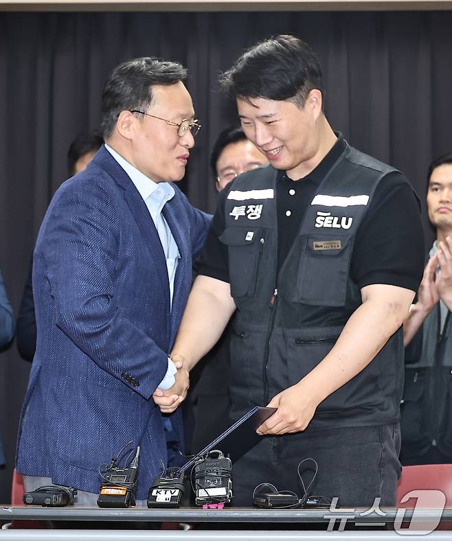 20일 경기 수원시 장안구 경기고용노동청에서 열린 삼성전자 임금협상을 마친 후 여명구 삼성전자 DS(디바이스솔루션·반도체 사업 담당) 피플팀장과 최승호 삼성그룹 초기업노동조합 삼성전자지부 위원장이 잠정 합의안에 서명한 후 악수를 하고 있다. (공동취재) 2026.5.20 ⓒ 뉴스1 김영운 기자