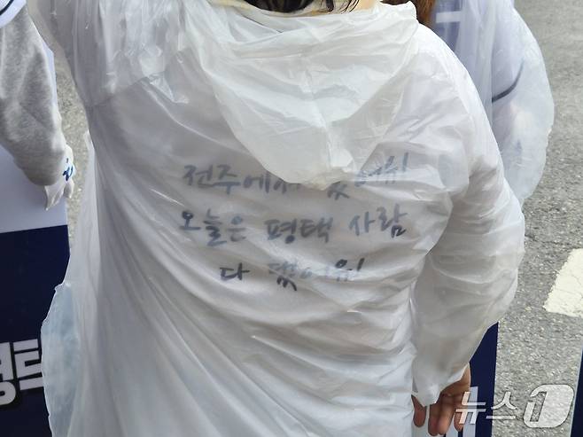 조국 조국혁신당 경기 평택을 국회의원 재선거 후보가  평택시 고덕면 해창리 KTX 경기남부역 예정 부지에서 공식선거운동 출정식을 연 21일 오전 한 지지자가 등판에 '전주에서 왔어유. 오늘은 평택 사람 다 댔어유!'라고 적힌 티셔츠를 입고 응원의 목소리를 전하고 있다. 2026.5.21 ⓒ 뉴스1 김기현 기자