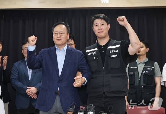 20일 경기 수원시 장안구 경기고용노동청에서 열린 삼성전자 임금협상을 마친 후 여명구 삼성전자 반도체(DS) 피플팀장(왼쪽)과 최승호 삼성그룹 초기업노동조합 삼성전자지부 위원장이 잠정 합의안에 서명한 후 파이팅을 외치고 있다. (공동취재) 2026.5.20/뉴스1