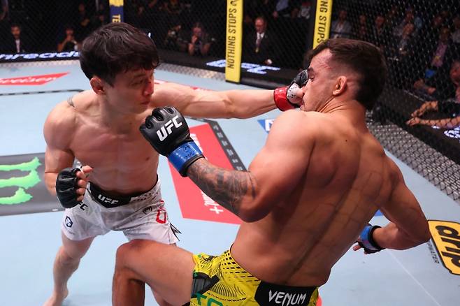 최두호(왼쪽)가 다니엘 산토스에게 펀치를 적중하고 있다. 사진=UFC