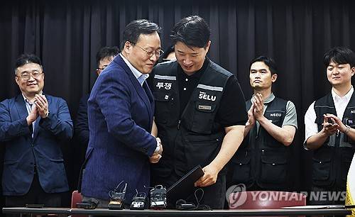 삼성전자 파업 유보 (수원=연합뉴스) 홍기원 기자 = 20일 경기도 수원시 장안구 경기고용노동청에서 열린 삼성전자 임금협상을 마친 후 여명구 삼성전자 DS(디바이스솔루션·반도체 사업 담당) 피플팀장과 최승호 삼성그룹 초기업노동조합 삼성전자지부 위원장이 잠정 합의안에 서명한 후 손을 맞잡고 있다. 2026.5.20 [공동취재] xanadu@yna.co.kr