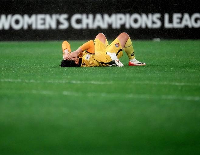수원FC 위민 골키퍼 김경희가 20일 수원종합운동장에서 열린 AFC 여자 챔피언스리그 4강전에서 북한 내고향여자축구단에 1-2로 패한 뒤 그라운드에 누워있다. 작은 사진은 승리 뒤 기념촬영 중인 내고향축구단. AP연합뉴스