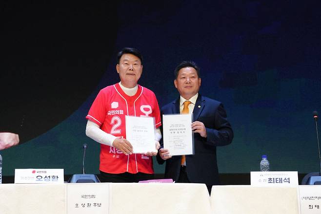 당진지역사회연구소 최태석 소장이 오성환 당진시장 후보에게 서면질의서를 전달하고 있다.(사진=오성환 캠프 제공)