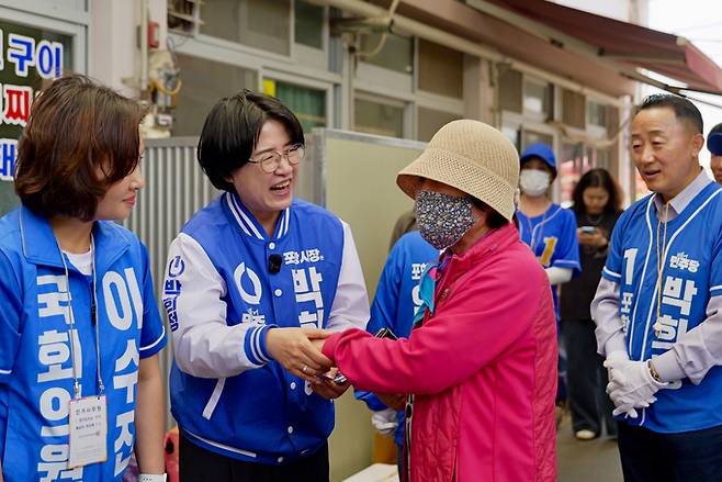 ▲ 22일 오후 박희정 더불어민주당 포항시장 후보와 당 소속 국회의원들이 포항 흥해시장을 찾았다. 사진은 박 후보가 한 어르신의 손을 잡고 지지를 호소하는 모습. 박희정 캠프 제공
