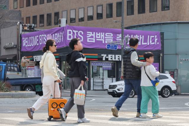 방탄소년단(BTS) 공연으로 큰 경제효과를 전망하는 가운데 22일 서울 종로구 광화문광장 인근 편의점에 BTS 응원 현수막이 걸려 있다. 22일 세븐일레븐에 따르면 광화문과 명동 상권 40개 점포 매출이 전달 같은 요일 대비 2.2배로 늘었다. 공연장 인근 핵심 점포 5개 점의 매출은 평소보다 7배까지 치솟았다. 여행 플랫폼 올마이투어에 따르면 공연이 열린 21일이 포함된 이달 셋째 주 외국인의 숙소 예약은 전주 대비 103% 증가했고 작년 같은 기간과 비교해 63% 늘었다. 연합뉴스