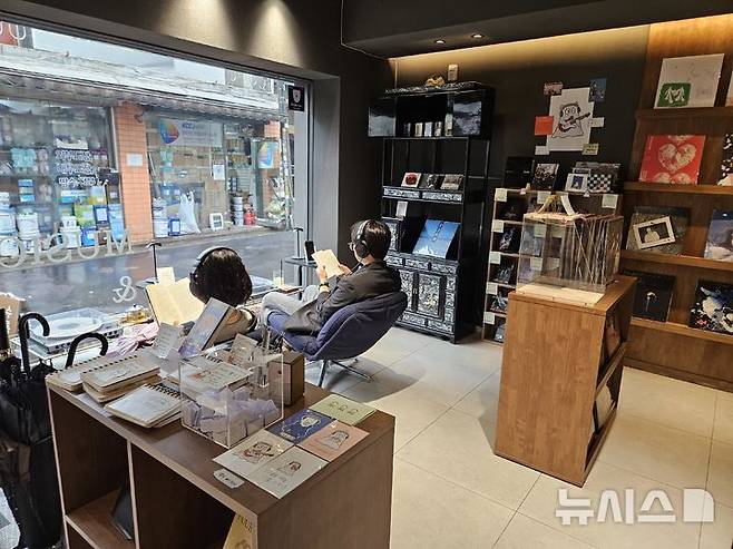 [서울=뉴시스]염지윤 인턴기자=서울 대흥동에 위치한 청음책방 '수록곡기록실' 방문객들이 20일 헤드폰을 착용하고 LP로 음악을 들으며 책을 읽고 있다. 2026.05.20.