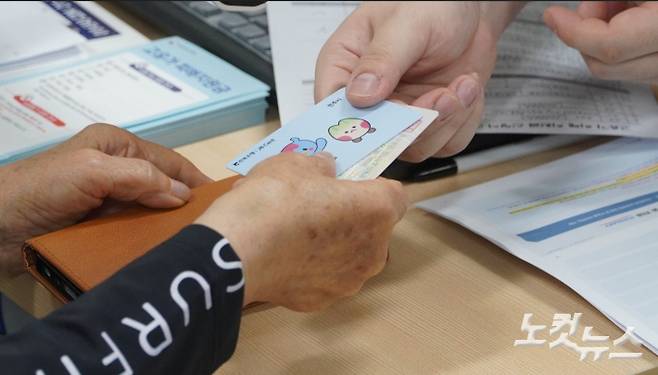 지난 8일 전주시 서신동 주민센터에서 고유가지원금을 신청한 주민이 선불카드를 받고 있다. 고유가지원금 카드에 점자가 없다. 심동훈 기자