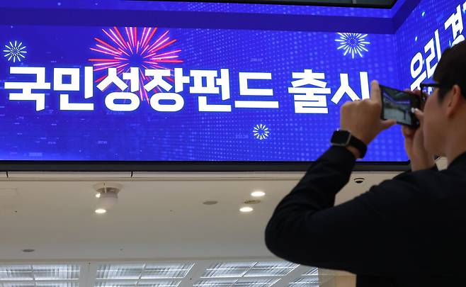 22일부터 주요 시중은행들은 국민참여형 국민성장펀드를 선착순으로 판매한다. 사진은 21일 서울 중구 우리은행 본점 로비 스크린에 관련 안내문이 나오는 모습 ⓒ 연합뉴스