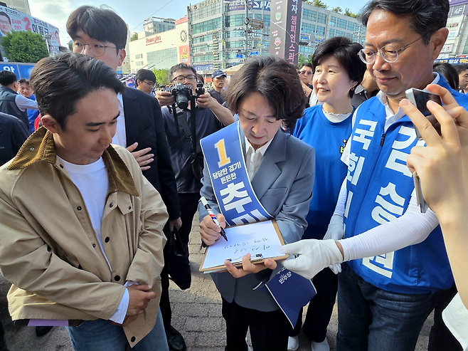 ▲ 추미애 더불어민주당 경기도지사 후보가 23일 수원시 장안구 KT위즈파크 앞 거리 유세 현장에서 지지자의 사인 요청에 "함께 승리해 꿈을 이룹시다"라는 문구를 적어주고 있다./박다예 기자 pdyes@incheonilbo.com