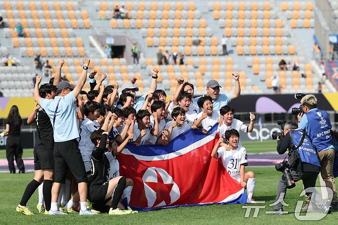 23일 오후 경기 수원시 수원종합운동장에서 열린 2025-2026 아시아축구연맹(AFC) 여자 챔피언스리그(AWCL) 결승 도쿄 베르디의 경기에서 1-0으로 승리하며 사상 첫 정상에 오른 내고향여자축구단 선수들이 인공기를 들고 기념촬영을 하고 있다. 2026.5.23 ⓒ 뉴스1 박지혜 기자