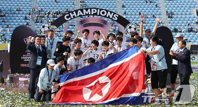 23일 오후 경기 수원시 수원종합운동장에서 열린 2025-2026 아시아축구연맹(AFC) 여자 챔피언스리그(AWCL) 결승 북한 내고향여자축구단과 도쿄 베르디의 경기에서 우승을 거둔 내고향 선수들이 인공기를 펼쳐 기념 촬영을 하고 있다. 2026.5.23 ⓒ 뉴스1 박지혜 기자