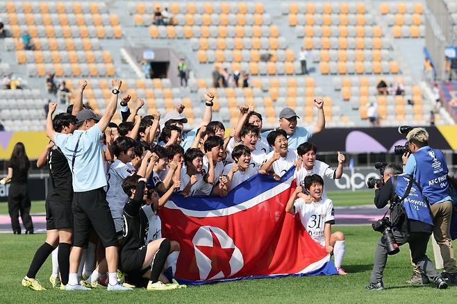 23일 수원종합운동장에서 아시아축구연맹 여자 챔피언스리그 우승을 차지한 북한 내고향여자축구단이 인공기를 들고 기념 촬영을 하고 있다. 뉴스1